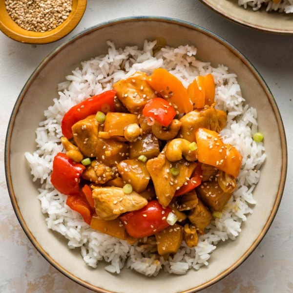 Bowls of pineapple chicken served with rice.