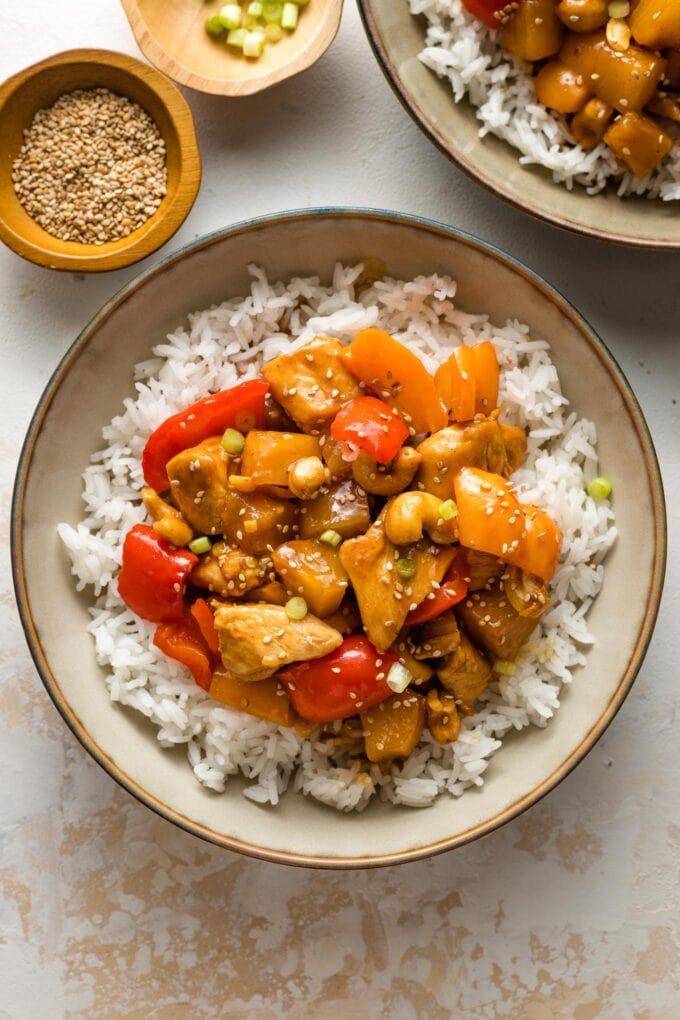 Bowls of pineapple chicken served with rice.