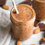 Close-up of a chocolate almond milk smoothie with chia seeds sprinkled on top.