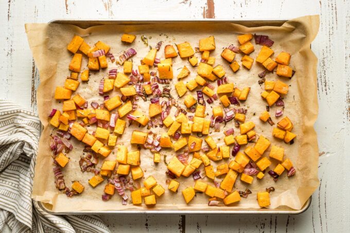 Baking sheet with roasted squash and onions.