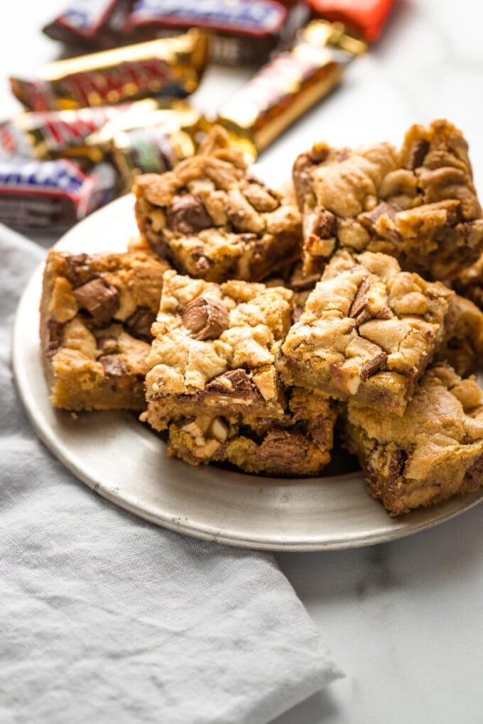 Blondies with candy bars mixed in, arranged on a small plate.