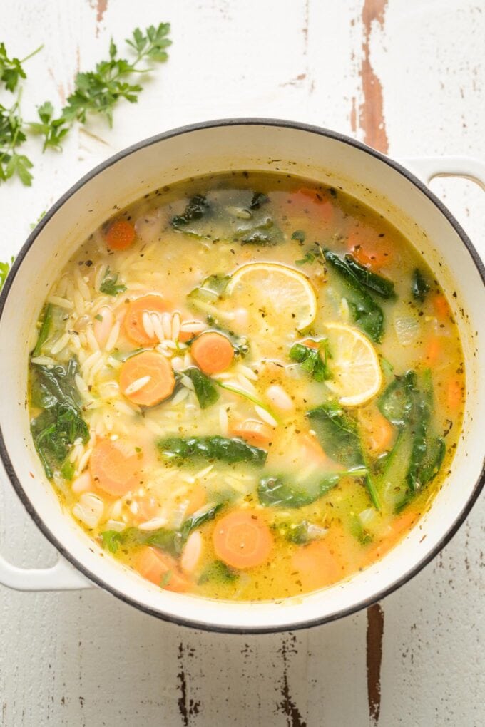 Large pot of white bean and spinach soup with orzo and lemon.
