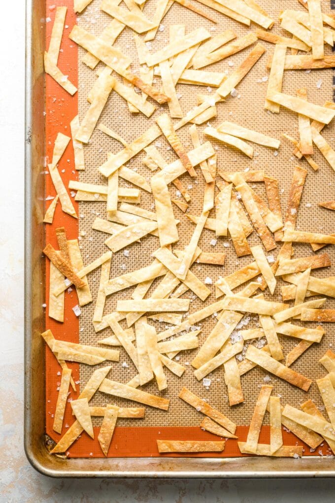 Baked tortilla strips on a sheet pan.