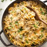 Large skillet full of sausage noodle casserole ready to serve.