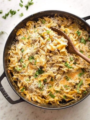 Large skillet full of sausage noodle casserole ready to serve.