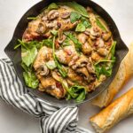 Creamy balsamic chicken with spinach and mushrooms cooked in a cast iron skillet.