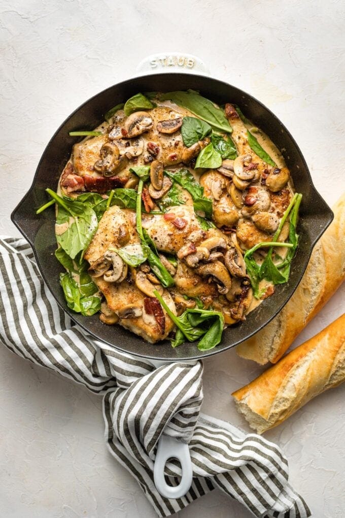 Creamy balsamic chicken with spinach and mushrooms cooked in a cast iron skillet.