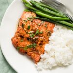 Plate with a salmon filet, rice, and green beans.