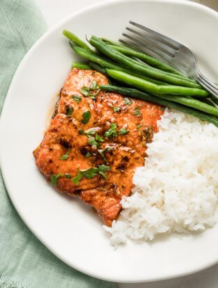 Plate with a salmon filet, rice, and green beans.