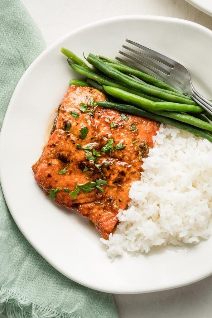Plate with a salmon filet, rice, and green beans.