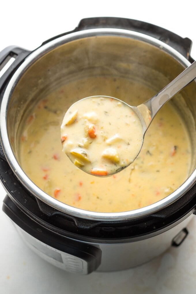 Ladle serving potato cheddar chowder straight from the Instant Pot.