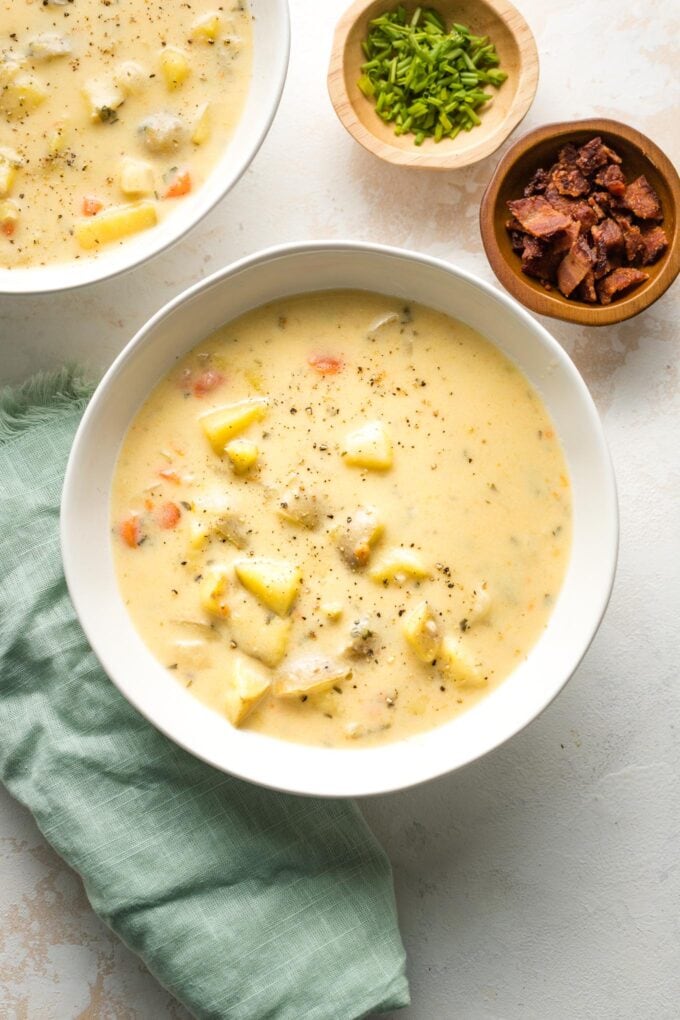 Bowls of Instant Pot potato cheddar chowder, ready to be garnished and served.