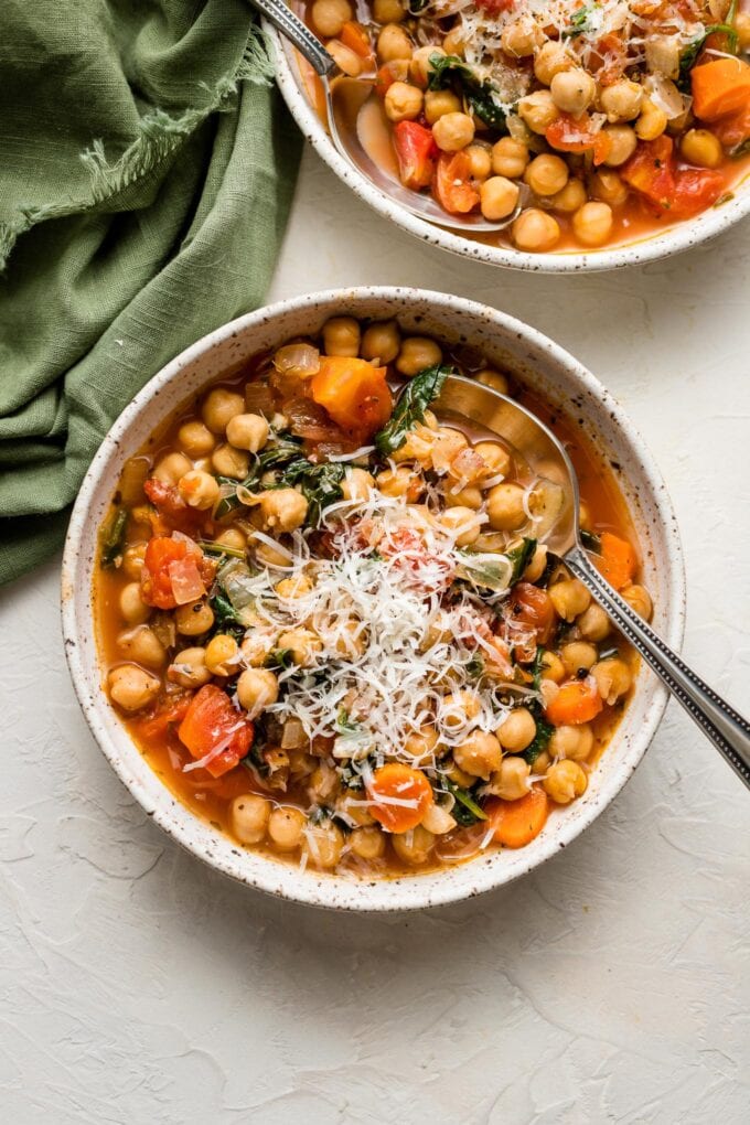 Bowls of chickpea stew served with fresh-grated Parmesan.