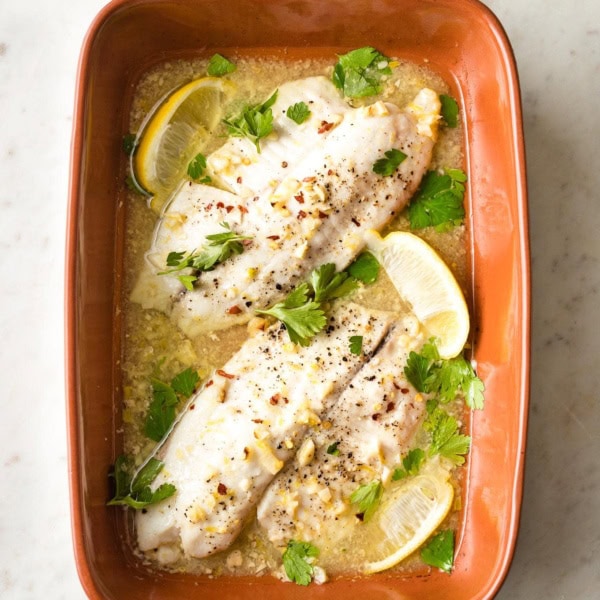 Baked tilapia with lemon in an earthenware pan.