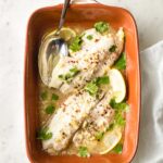 Baked tilapia with lemon in an earthenware pan.