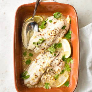 Baked tilapia with lemon in an earthenware pan.