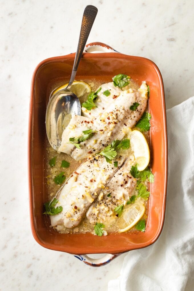 Baked tilapia with lemon in an earthenware pan.