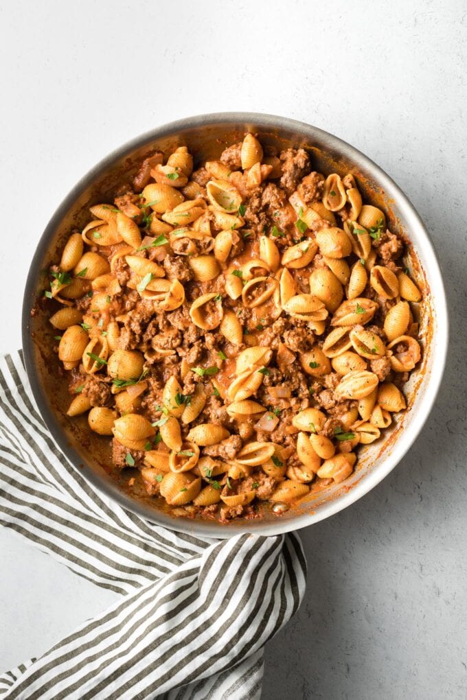 Overhead image of chili garlic beef and shells in a skillet.