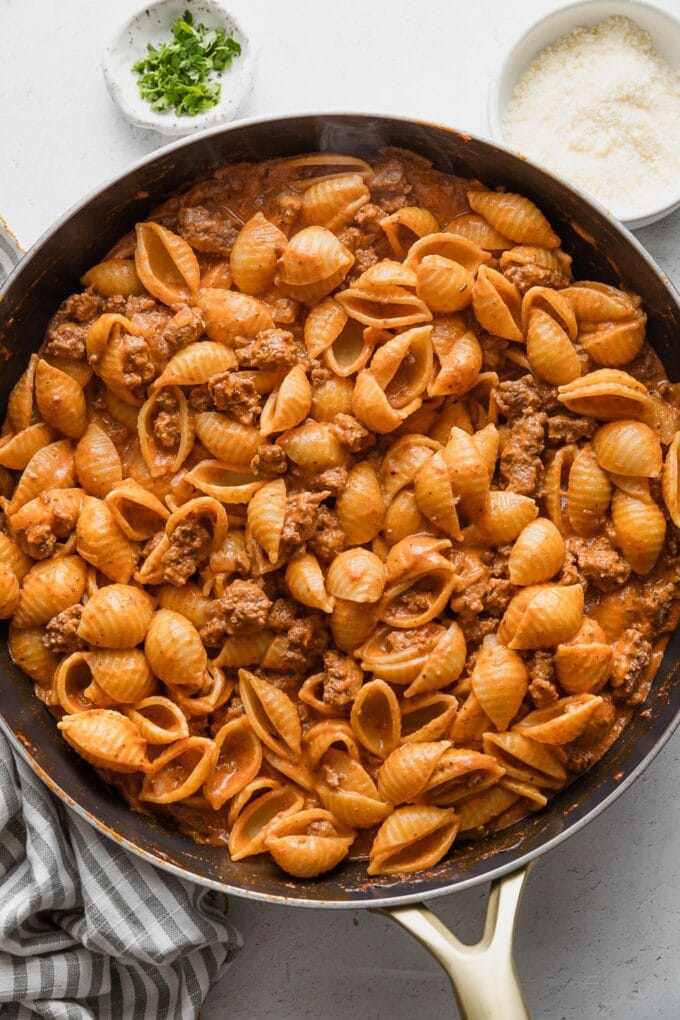 Skillet full of creamy ground beef and shells.
