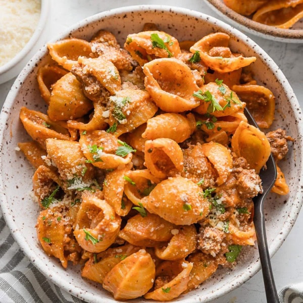 Bowl full of pasta with ground beef and a light chili powder and garlic infused tomato cream sauce.