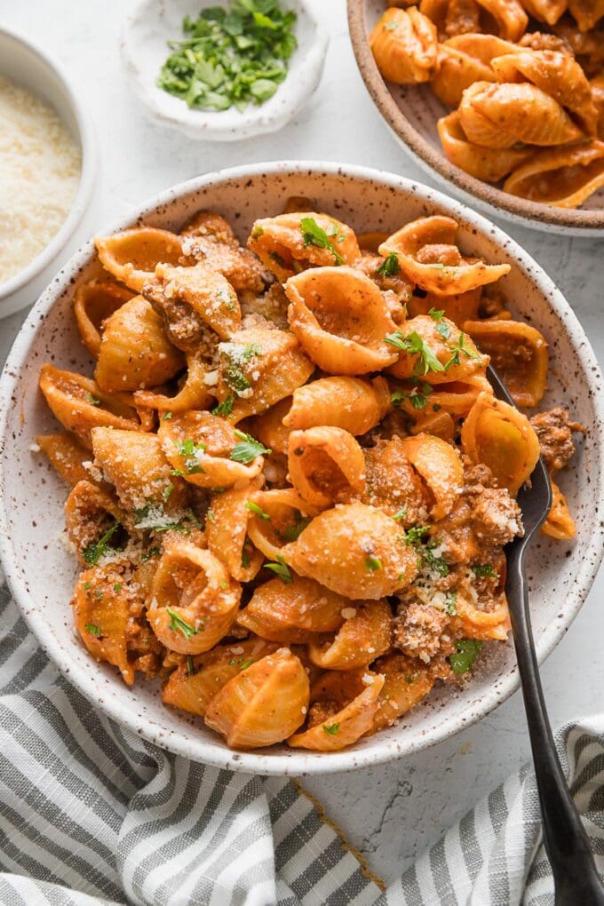 Bowl full of pasta with ground beef and a light chili powder and garlic infused tomato cream sauce.
