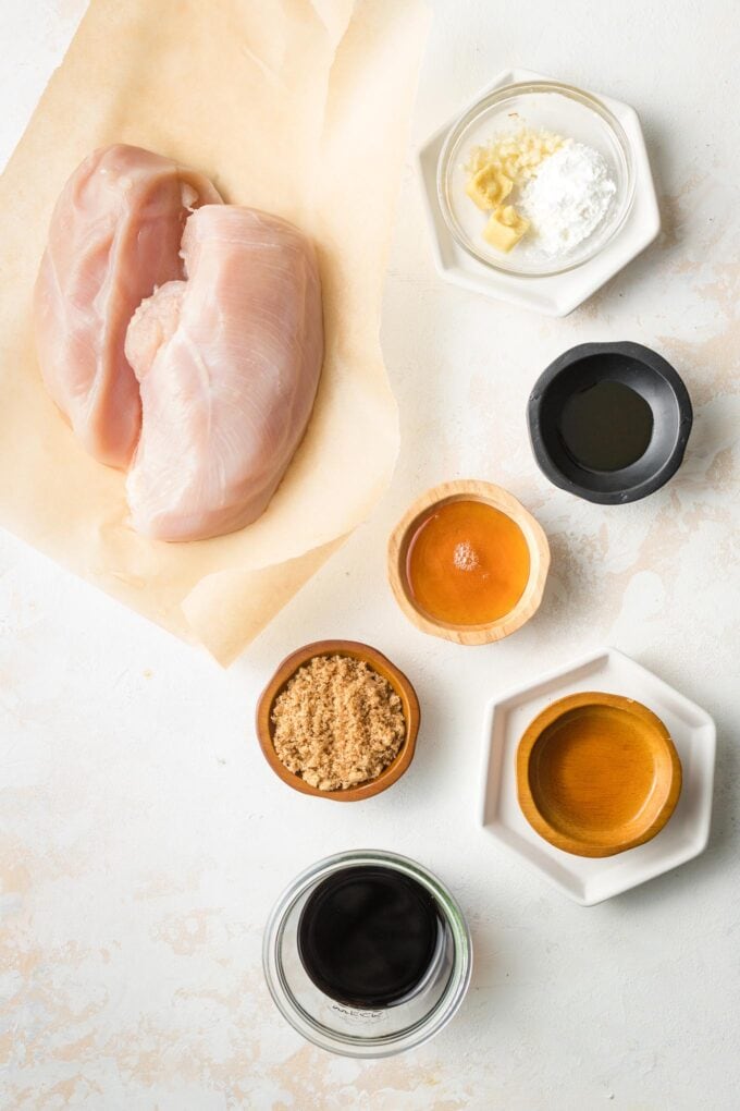 Chicken breasts, cornstarch, honey, apple cider vinegar, brown sugar, soy sauce, ginger, and garlic in prep bowls.