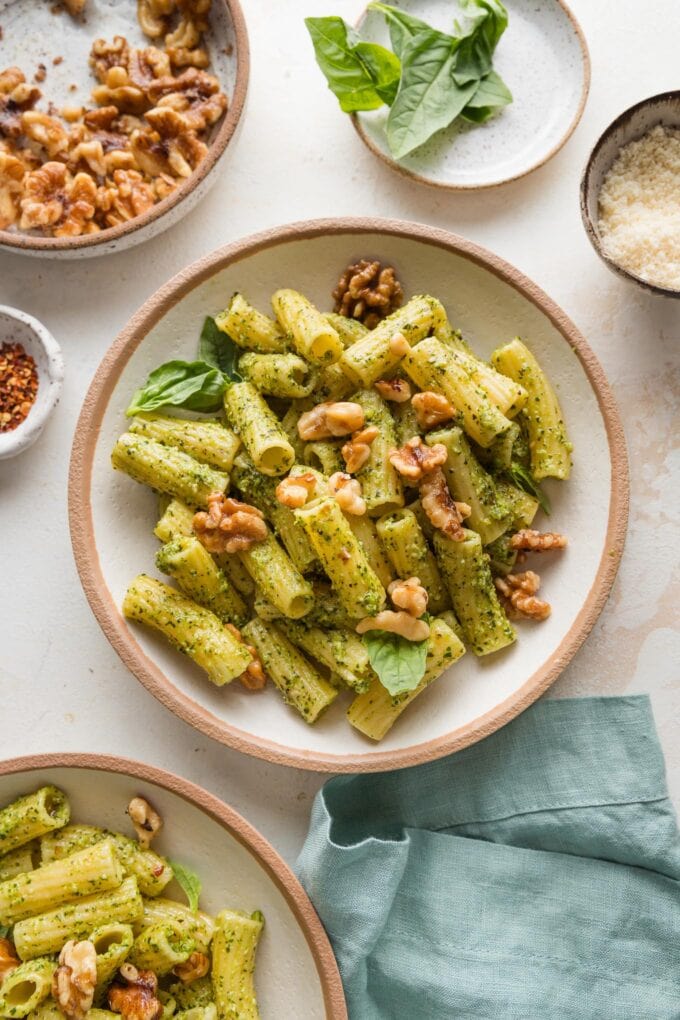 Countertop set with bowls of pesto rigatoni.