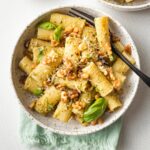 Bowls of rigatoni with pesto and toasted walnuts.