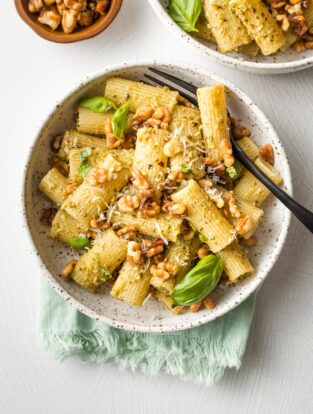 Bowls of rigatoni with pesto and toasted walnuts.