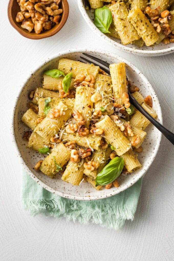 Bowls of rigatoni with pesto and toasted walnuts.