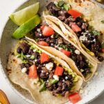Plate with three black bean tacos.