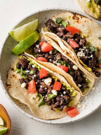 Plate with three black bean tacos.