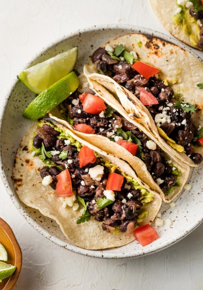Plate with three black bean tacos.