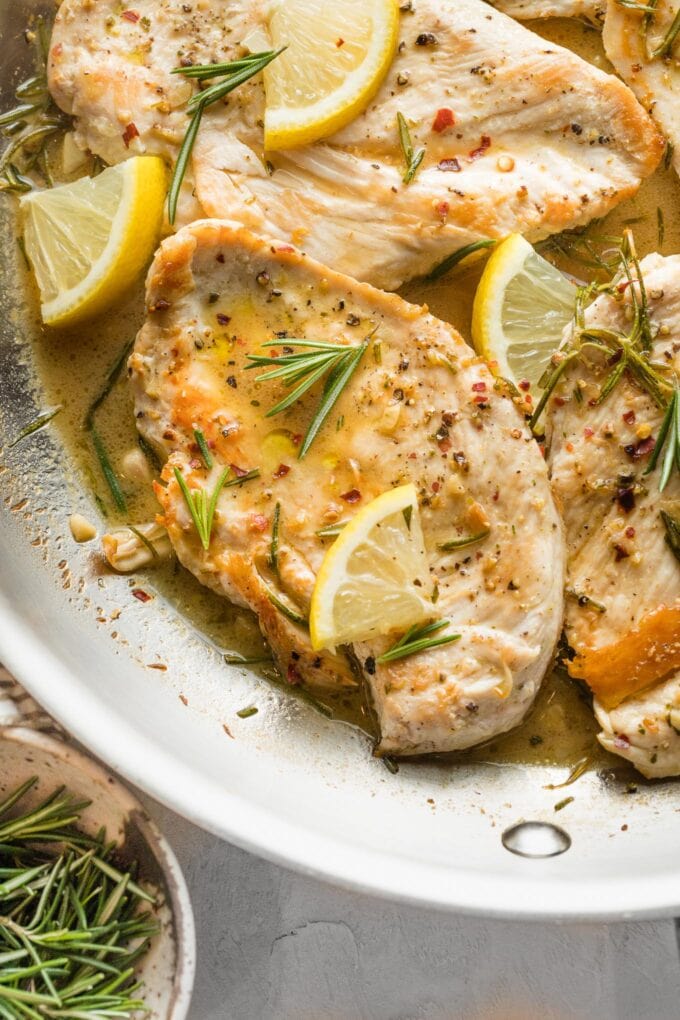 Close up of a chicken cutlet served with a lemon rosemary pan sauce.