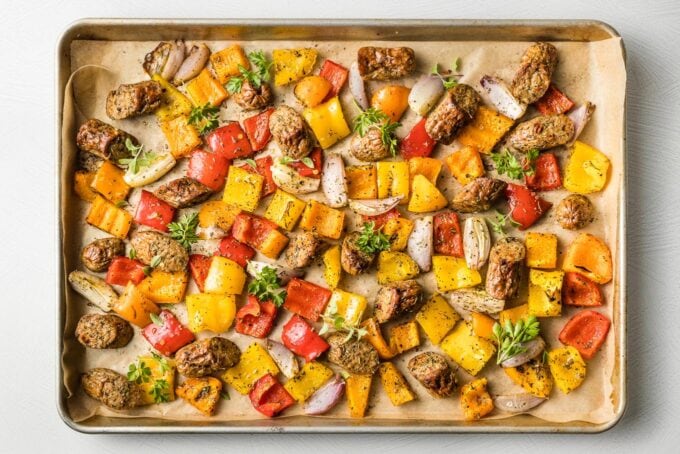 Sausages and veggies on the sheet pan after roasting.