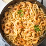 Skillet filled with blackened shrimp Alfredo, mixed together and ready to serve.