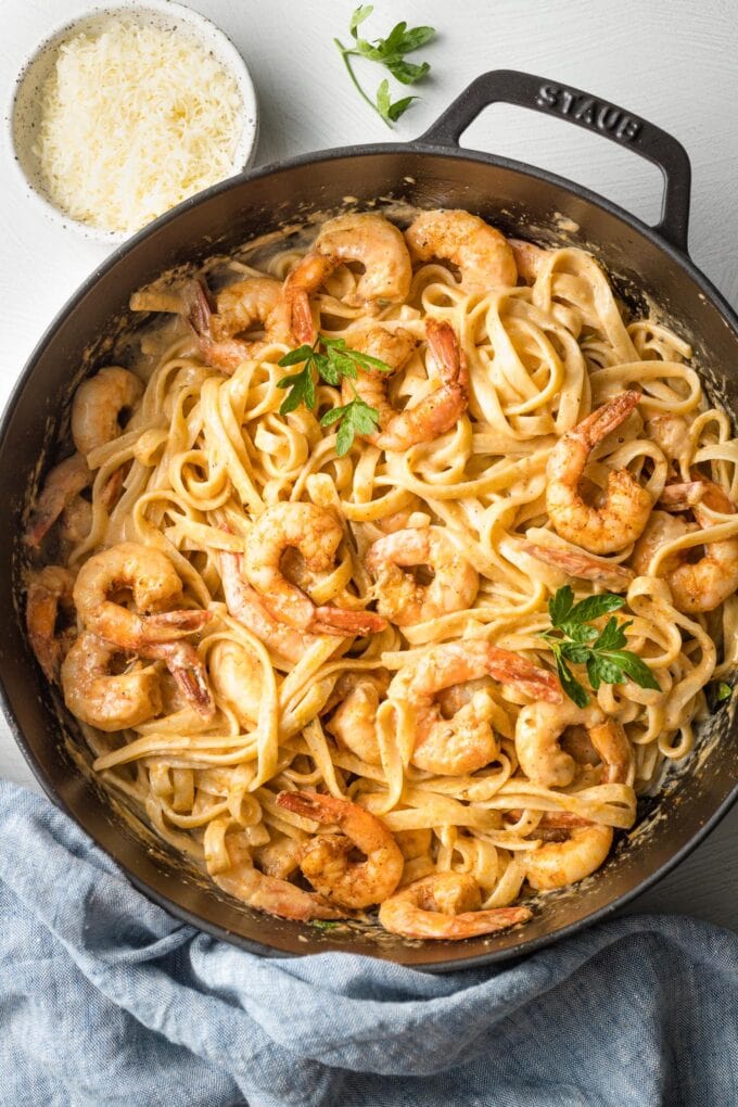 Skillet filled with blackened shrimp Alfredo, mixed together and ready to serve.