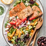 Greek salmon salad served on a white platter.