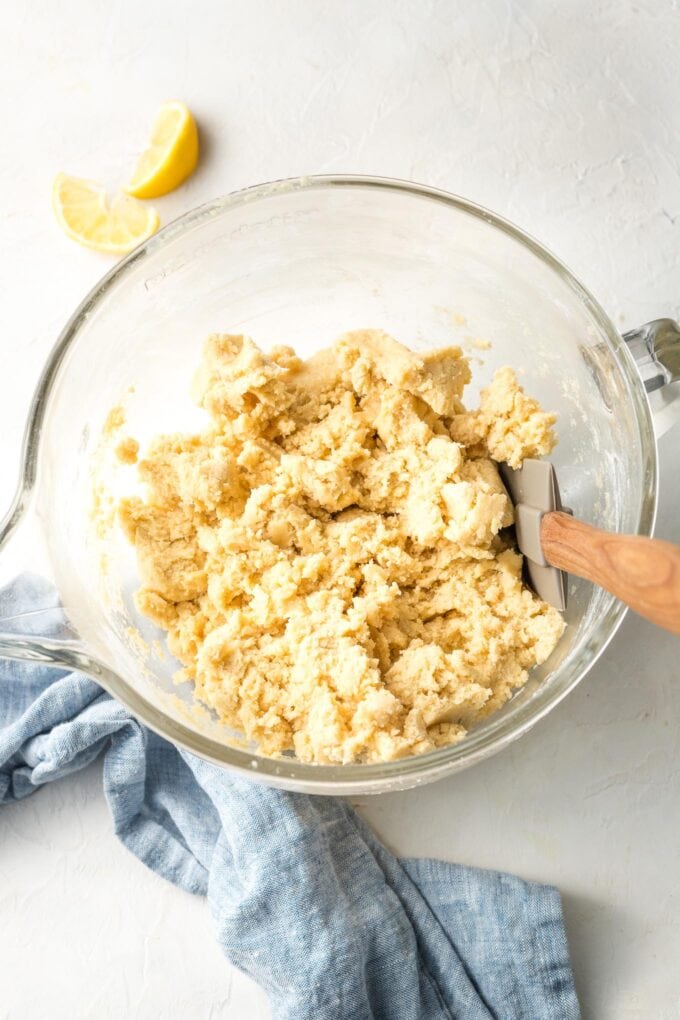 Overhead image of a clear glass Kitchen Aid bowl holding lemon sugar cooke dough.