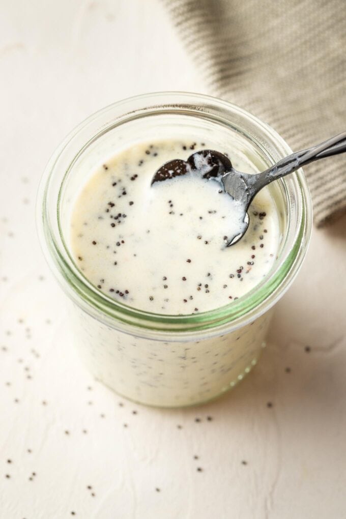 Small jar holding homemade honey poppy seed dressing.