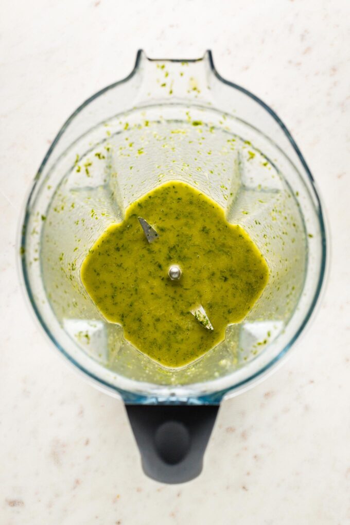 Cilantro lime salad dressing blended together in the bowl of a Vitamix.