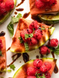 Watermelon Raspberry Mint Wedges: summer on a plate! Slices of crisp watermelon piled high with sweet berries, dusted with zippy mint, lime, and sea salt, then drizzled with tangy balsamic glaze. Serve as an appetizer, snack, or even a salad.