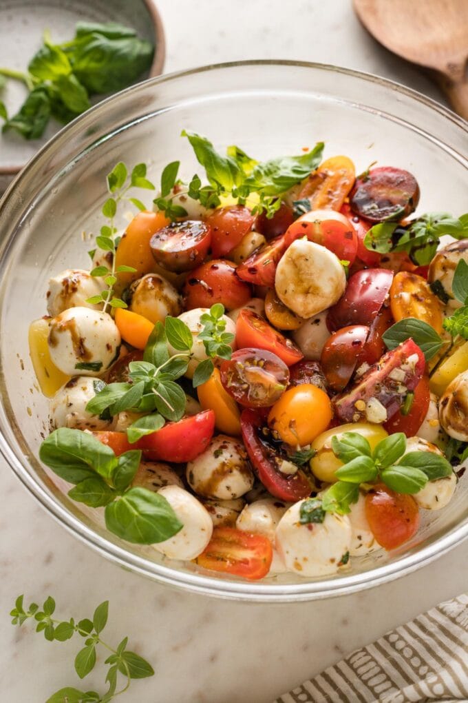 Side view of the bowl of marinated mozzarella with tomatoes.