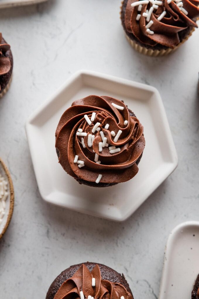 Close up of a chocolate buttermilk cupcake with a rosette piped of chocolate frosting on top.