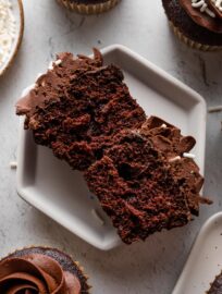 Interior view of a chocolate buttermilk cupcake, showing a moist, tender crumb interior and simple chocolate frosting on top.