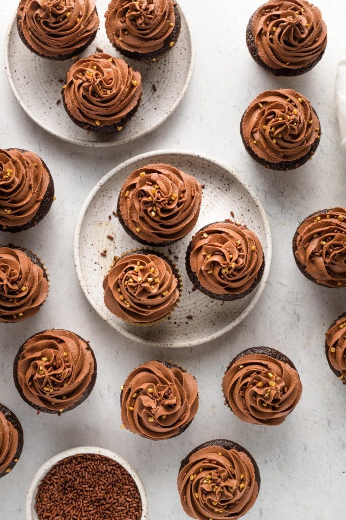 Overhead image of chocolate buttermilk cupcakes frosted with large swirls of chocolate frosting.