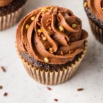 Close up of a chocolate buttermilk cupcake with gold sprinkles.