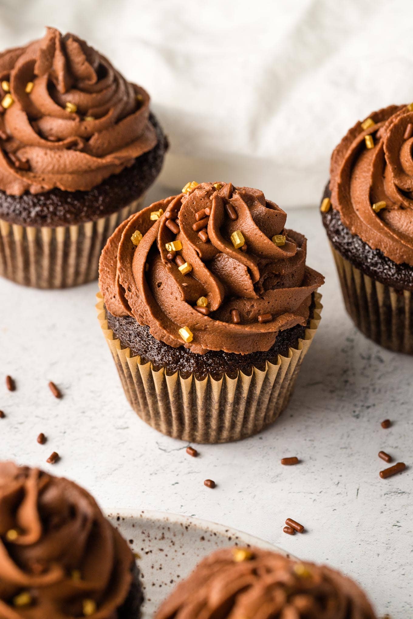 Chocolate buttermilk cupcakes decorated with gold and chocolate sprinkles.