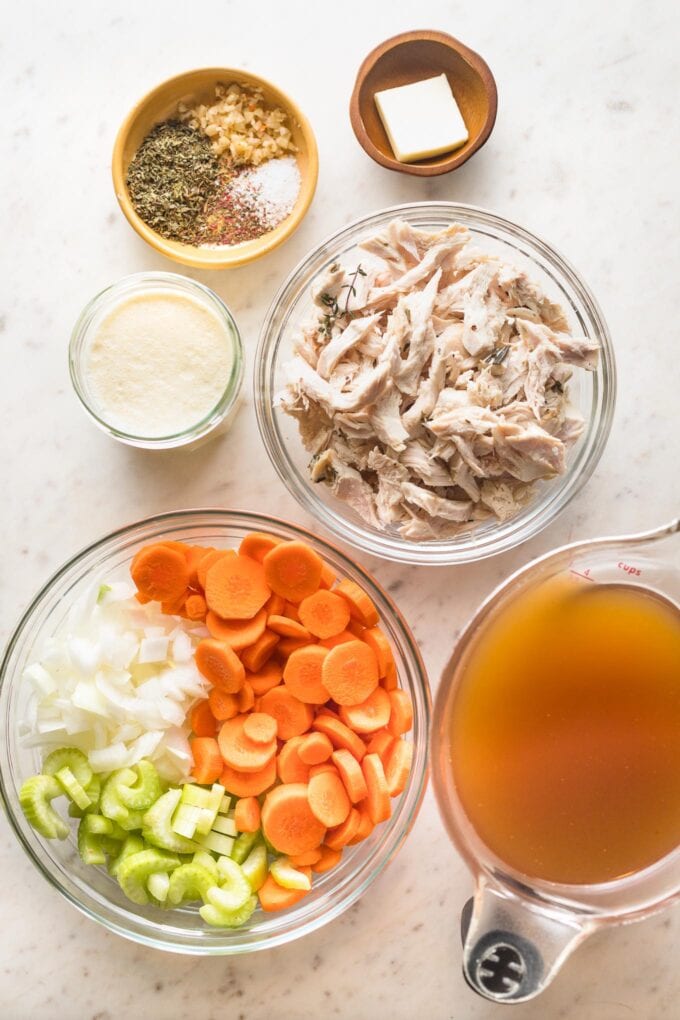 Prep bowls with shredded turkey, carrots, onion, celery, broth, cream, butter, and seasonings.