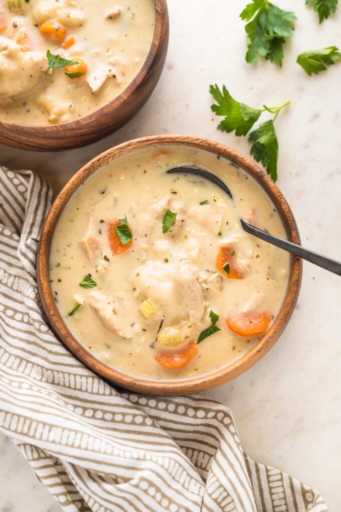 Bowls of turkey and dumplings, garnished with fresh parsley.